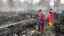 Pelajar bernama Rudiansyah dengan mengenakan kostum Superman membantu memadamkan kebakaran hutan dan lahan di Petuk Katimpun, Palangkaraya, Kalimantan Tengah, 17 Agustus 2026. (AFP/ Reina)