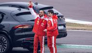 Pembalap Inggris Ferrari, Lewis Hamilton (kiri) dan pembalap Monako Ferrari, Charles Leclerc, melambaikan tangan kepada penggemar setelah menguji mobil Formula 1 Ferrari SF-26 yang baru di Sirkuit Fiorano di Fiorano Modenese pada 23 Januari 2026. (Federico SCOPPA/AFP)