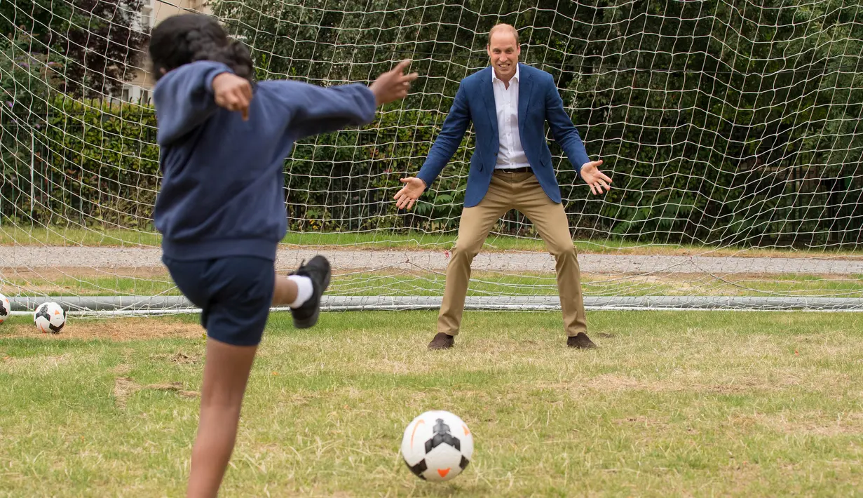 Pangeran William menjadi kiper ketika menyempatkan diri bermain bersama anak-anak program pendidikan sepak bola Wildcats Girls saat mengunjungi tim sepak bola wanita Inggris, di Kensington Palace, London, Kamis (13/7). (Dominic Lipinski / POOL / AFP)