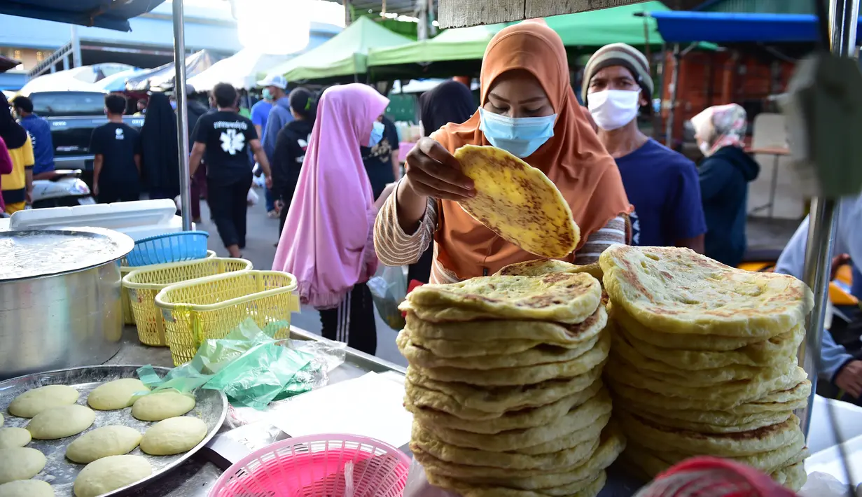 Seorang pedagang membuat roti di pasar makanan pada hari pertama bulan suci Ramadhan di provinsi Narathiwat di Thailand selatan (24/4/2020). Sejumlah pedagang menjual berbagai makanan selama bulan suci Ramadan di pasar tersebut. (AFP/Madaree Tohlala)
