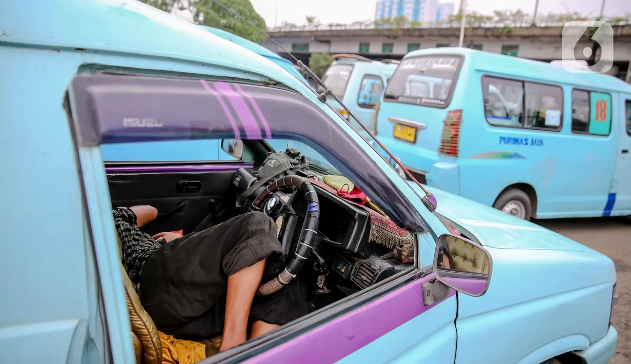 Sopir beristirahat di dalam angkutan kota (angkot) di Terminal Kampung Melayu, Jakarta, Kamis (30/4/2020). Ketua Organda DKI Shafruhan Sinungan mengatakan dari sekitar 85.900 kendaraan yang berada di bawah naungannya, hanya 8.000-8.600 unit yang masih dapat beroperasi. (Liputan6.com/Faizal Fanani)