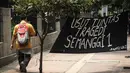 Spanduk berisi tuntutan pengusutan kasus Tragedi Semanggi terbentang di depan Kampus Unika Atma Jaya, Jakarta, Kamis (13/11/2014). (Liputan6.com/Faizal Fanani)