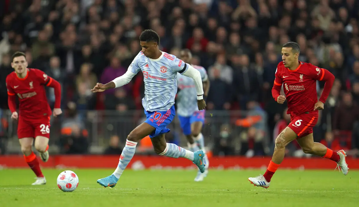 Pemain Manchester United Marcus Rashford (kiri) menggiring bola melewati pemain Liverpool Thiago (kanan) pada pertandingan sepak bola Liga Inggris di Stadion Anfield, Liverpool, Inggris, 19 April 2022. Liverpool menang 4-0. (AP Photo/Jon Super)