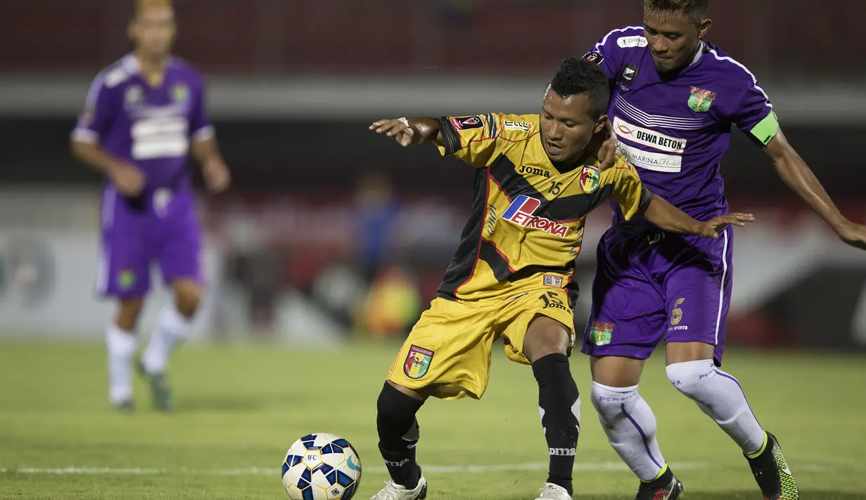 Pemain Mitra Kukar, Hendra Bayau berusaha melewati pemain Persita, Maman Abdulrahman pada laga Piala Presiden di Stadion Dipta, Bali, Minggu (30/8/2015). (Bola.com/Vitalis Yogi Trisna)