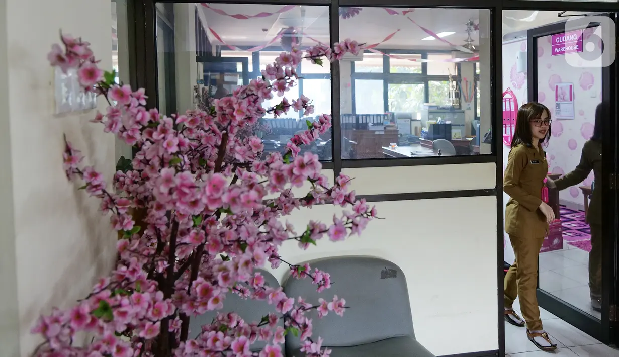 Bendahara Pengeluaran Kelurahan Rawa Bunga, Annastasia Sindi sedang keluar ruangan di kantor kelurahan Rawa Bunga, Jakarta, Senin (7/10/2019). Annastasia Sindi merubah warna kesukaannya warna pink (merah muda)  untuk menyemangati dalam bekerja. (Liputan6.com/Herman Zakharia)