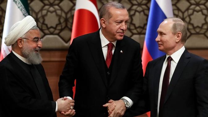 Ekspresi Presiden Turki Recep Tayyip Erdogan (tengah) saat bersama Presiden Rusia Vladimir Putin (kanan) dan Presiden Iran Hassan Rouhani (kiri) setelah menggelar pertemuan terkait perdamaian Suriah di Ankara, Turki, Rabu (4/4). (AFP PHOTO/ADEM ALTAN)