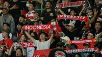 Suporter bernyanyi bersama saat memberikan dukungan kepada Timnas Indonesia U-19 yang bertanding melawan Myanmar pada laga Piala AFF U-19 2022 di Stadion Patriot Candrabhaga, Bekasi, Minggu (10/7/2022). (Bola.com/M Iqbal Ichsan)