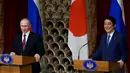 Presiden Rusia Vladimir Putin (Kiri) dan PM Jepang Shinzo Abe menggelar konferensi pers di Tokyo, Jepang, Jumat (16/12). Selain membahas soal wilayah sengketa, kedua belah pihak juga membahas situasi di semenanjung Korea. (REUTERS / Franck Robichon)