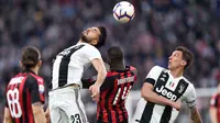 Gelandang Juventus, Emre Can, duel udara dengan gelandang AC Milan, Tiemoue Bakayoko, pada laga Serie A di Stadion Allianz, Turin, Sabtu (6/4). Juventus menang 2-1 atas AC Milan. (AP/Andrea Di Marco)