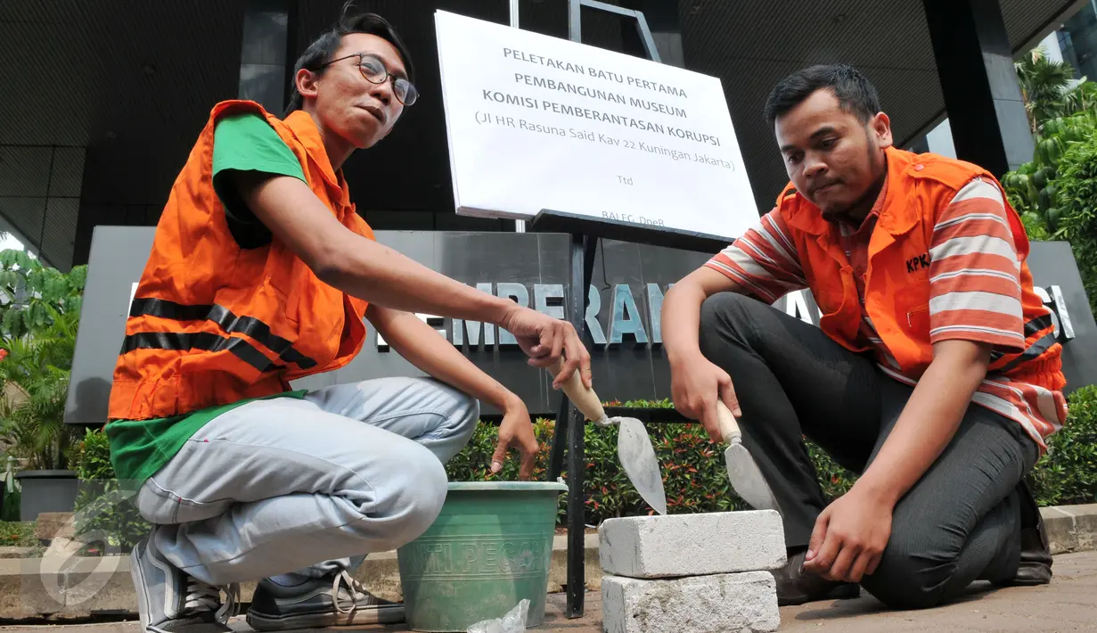 Dua orang dari Anggota Koalisi Pemantau Peradilan saat akan meletakkan batu pertama pembangunan museum KPK di halaman KPK, Jakarta, Kamis (8/10/2015). Mereka memprotes DPR yang berencana merevisi UU KPK NO.30 th 2002 (Liputan6.com/Andrian M Tunay)