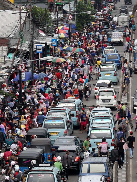 Sejumlah pengunjung berjalan di kawasan Tanah Abang, Jakarta, Senin (27/6). H-9 menjelang Idul Fitri 1437 H, Pusat perbelanjaan Tanah Abang semakin dipadati pengunjung yang ingin membeli kebutuhan lebaran terutama pakaian. (Liputan6.com/Gempur M Surya)