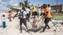Relawan membersihkan pantai secara berkelompok di pinggiran Dakar, Senegal (13/9/2020). Bersih-bersih pantai ini diharapkan dapat lebih banyak wisatawan akan tertarik mengunjungi pantai yang lebih bersih. (Xinhua/Louis Denga)