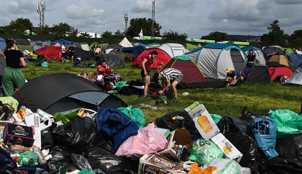 Setelah lima hari berpesta dan musik, orang-orang yang bersuka ria telah meninggalkan kemah di Worthy Farm, meninggalkan gunungan sampah plastik, tenda, dan tabung gas. (AFP/Oli Scarff)