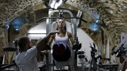 Binaragawan Anoush Belian saat berlatih dengan pelatihnya di tempat gym, Yerusalem (20/8/2015). Belian merupakan binaragawati pertama Palestina yang akan mengikuti kompetisi di Israel. (REUTERS/Ammar Awad)