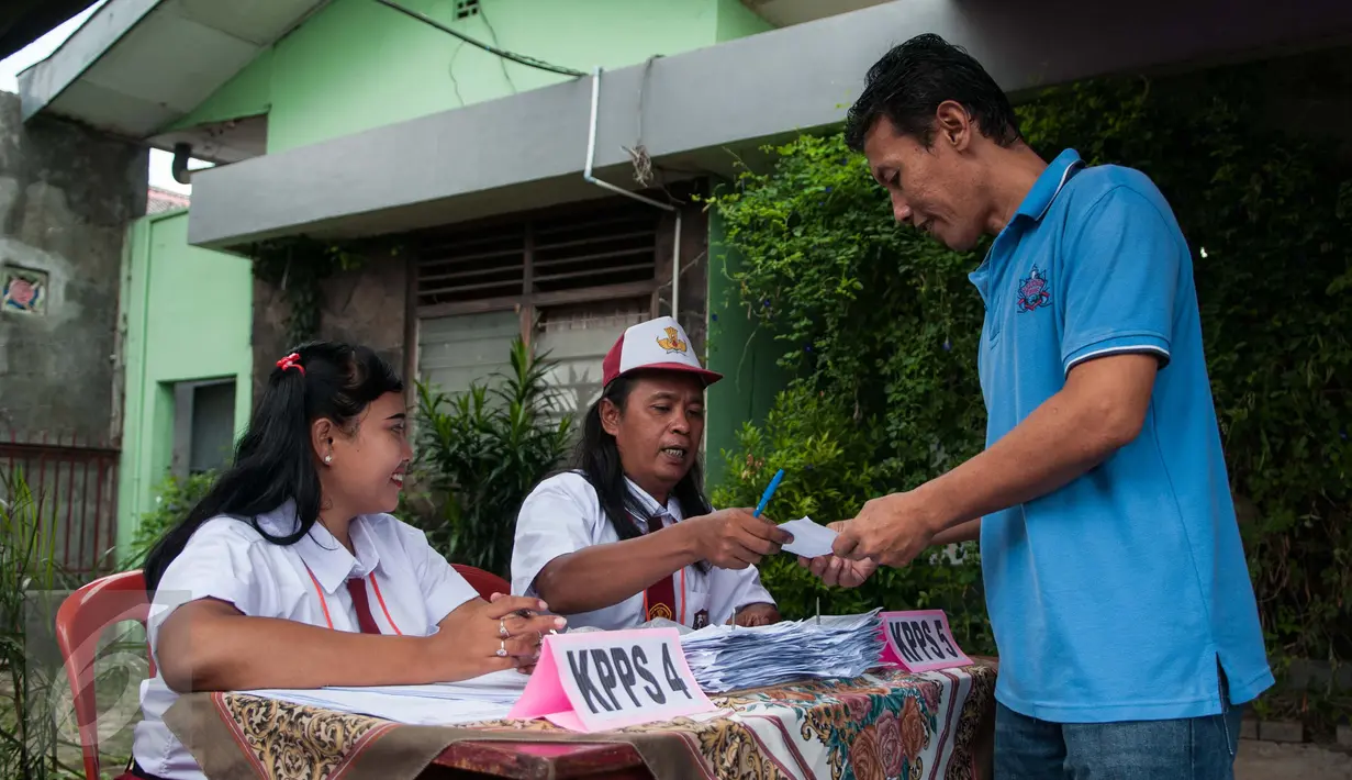 Petugas Kelompok Penyelenggara Pemungutan Suara (KPPS)  berseragam Sekolah Dasar memberikan pelayanan kepada warga yang menggunakan hak pilih pada Pilkada DKI 2017 di TPS 45 Kelurahan Kebon Pala, Jakarta, Rabu (15/2). (Liputan6.com/Gempur M Surya)