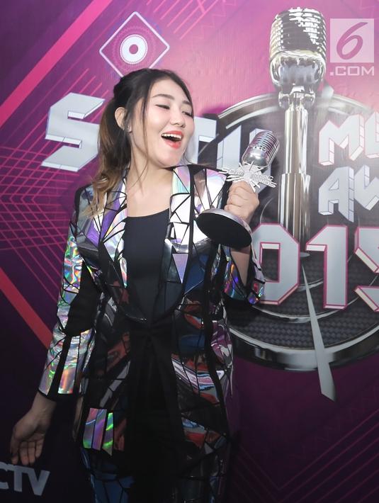 Penyanyi dangdut Via Vallen berpose dengan piala penghargaan usai acara SCTV Music Awards 2019 di Studio 6 Emtek City, Jakarta, Jumat (26/4). Via Vallen memboyong gelar Kategori Lagu Pop Paling Ngetop melalui "Meraih Bintang" yang sempat jadi Theme Song Asian Games 2018. (Fimela.com/Bambang E. Ros)