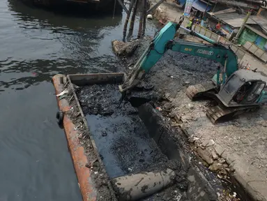 Alat berat mengangkat material endapan lumpur di Kampung Nelayan Cilincing, Jakarta Utara, Kamis (2/9/2021). Pengerukan dilakukan untuk mengurangi pendangkalan di muara teluk Jakarta serta penataan sandaran kapal-kapal tradisional. (merdeka.com/Imam Buhori)