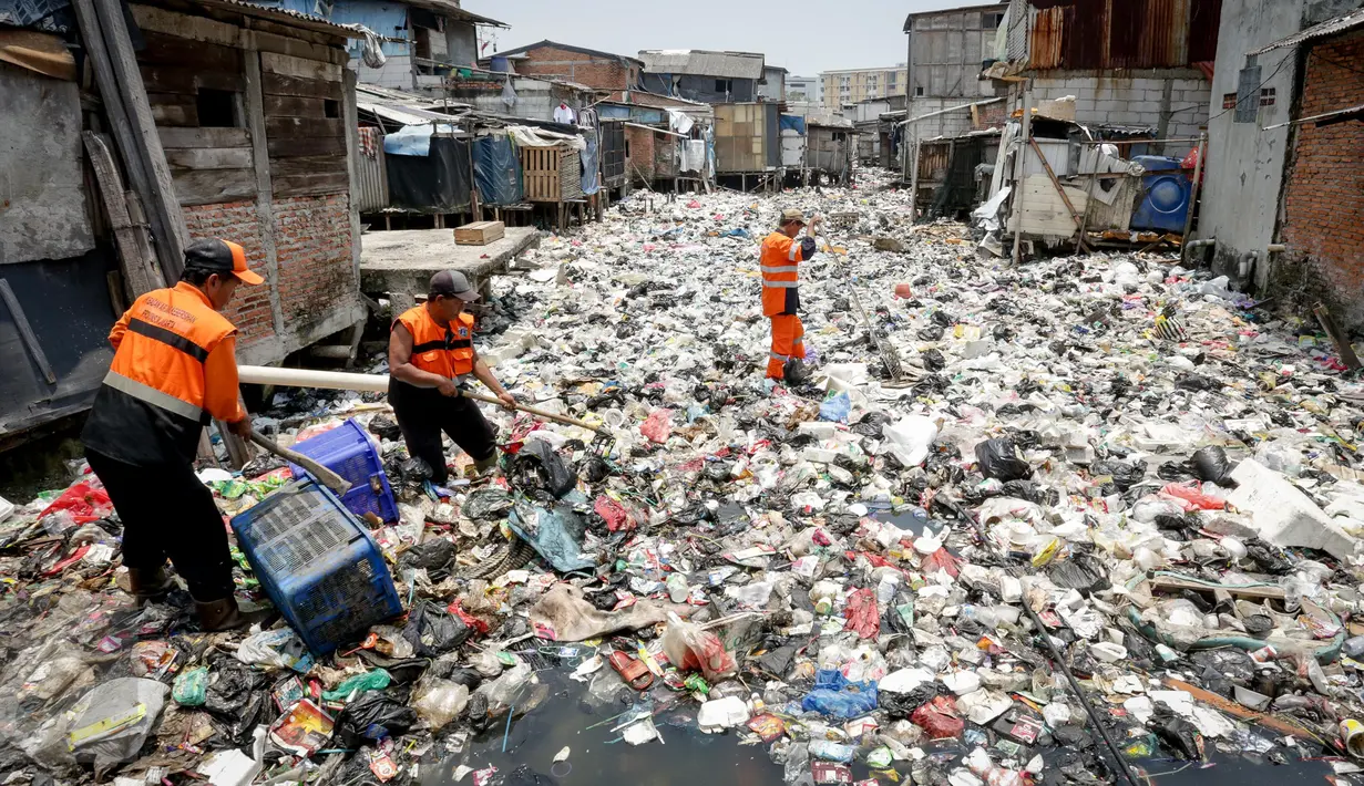Petugas membersihkan sampah yang menumpuk di Kali Gendong, Penjaringan, Jakarta Utara, Kamis (16/3). Ceceran sampah plastik limbah rumah tangga terlihat menyerupai daratan menumpuk di sepanjang Kali Gendong. (Liputan6.com/Faizal Fanani)
