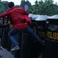 Seorang mahasiswa menendang tameng polisi yang berjaga saat unjuk rasa di Jalan Medan Merdeka Barat, Jakarta, Kamis (20/10). Mahasiswa menagih janji Nawacita pemerintahan Jokowi-JK. (Liputan6.com/Gempur M Surya)