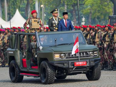 Presiden Republik Indonesia Joko Widodo didampingi Panglima TNI Jenderal TNI Agus Subiyanto (kedua kanan) dan komandan upacara Mayjen TNI Djon Afriandi (kiri) menginspeksi pasukan saat parade yang menandai ulang tahun ke-79 Tentara Nasional Indonesia di Lapangan Monumen Nasional (Monas) Jakarta, Sabtu, 5 Oktober 2024. (AP Photo/Tatan Syuflana)