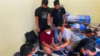 Pria yang menyamar menjadi wanita (masker putih) saat ditangkap Polda Riau karena mengancam menyebar video call sex. (Liputan6.com/M Syukur)