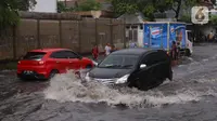 Pengendara terjebak banjir yang menggenangi jalan Bayangkara Pusdiklat, Kota Tangerang Selatan, Banten, Selasa (2/11/2021). Ada potensi hujan lebat dengan intensitas lebih dari 50 milimeter (mm) per hari. (Liputan6.com/Angga Yuniar)