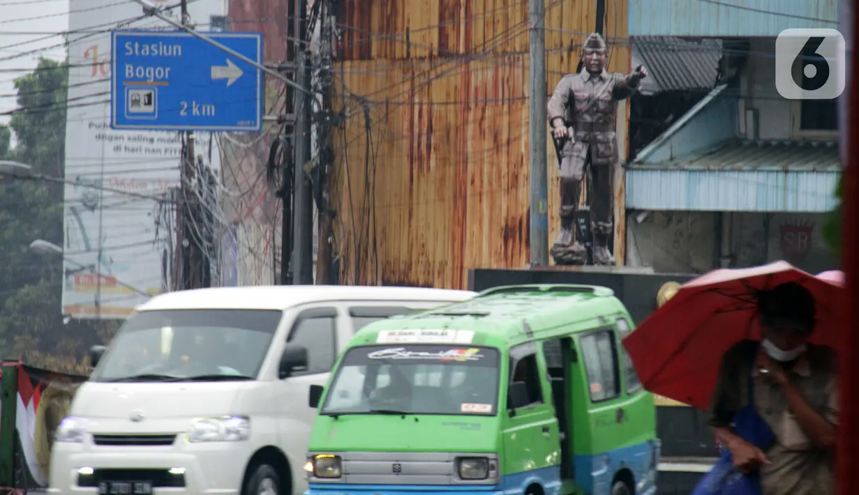 Kendaraan melintas di sekitar Patung Kapten Tubagus Muslihat, Simpang Jalan Kapten Muslihat, Kota Bogor, Jawa Barat, Senin (26/12/2022). Patung hasil karya seniman Yayat Darajat ini merekonstruksi wajah, tubuh dan perawakan pahlawan yang gugur di medan perang usai tertembak di Jembatan Merah. (Liputan6.com/Magang/Aida Nuralifa)