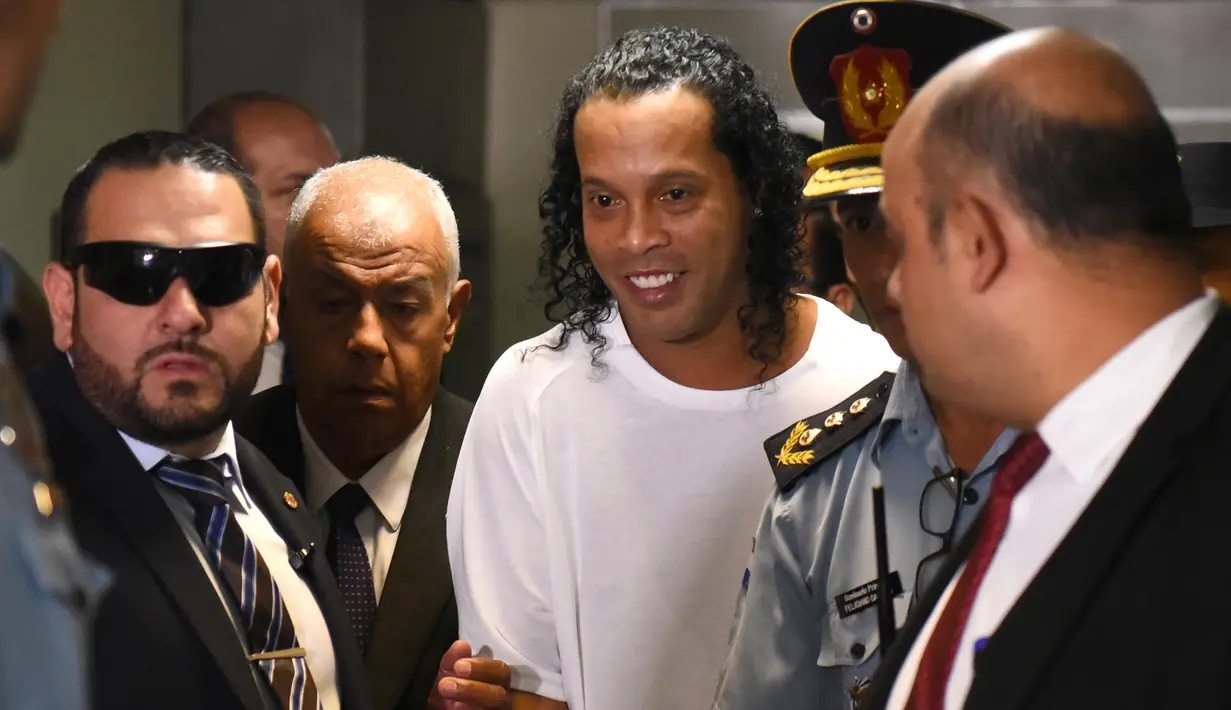 Mantan pemain timnas Brasil, Ronaldinho (tengah) tiba di Asuncion's Justice Palace, ibu kota Paraguay, Asuncion, Jumat (6/3/2020). Ronaldinho bersama saudara laki-lakinya berurusan dengan pihak berwenang Paraguay karena menggunakan paspor palsu untuk memasuki negara itu. (Norberto DUARTE/AFP)