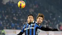 Gelandang Juventus Manuel Locatelli (kanan) menyundul bola di sebelah penyerang Atalanta Luis Muriel pada pekan ke-25 Liga Italia 2021-2022 di Gewiss Stadium, Senin (14/2/2022). Juventus bermain imbang 1-1 dengan tuan rumah Atalanta. (Andreas SOLARO / AFP)