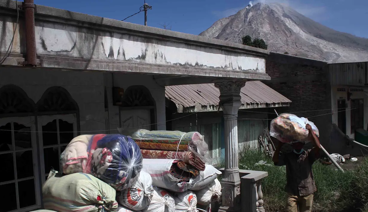 Warga desa Gamber mengemasi barang-barangnya untuk mencegah letusan susulan Gunung Sinabung, Karo, Sumatera Utara, (23/5). Bencana tersebut menyebabkan 7 orang meninggal dan 2 orang mengalami luka bakar akibat terkena awan panas. (Albert Damanik / AFP)