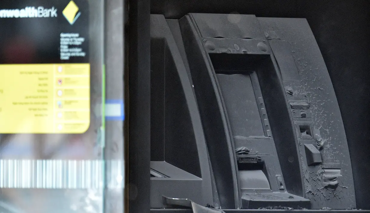 Sebuah mesin ATM hangus terbakar di kantor cabang Commonwealth Bank of Australia di Melbourne, Jumat (18/11). Sedikitnya 27 korban luka akibat seorang pria membakar dirinya sendiri di kantor cabang bank tersebut. (AAP/Julian Smith/via REUTERS) 