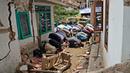 Umat muslim melaksanakan salat Jumat di luar masjid yang rusak parah akibat gempa di Desa Gasol, Cianjur, Jawa Barat, Indonesia, Jumat (25/11/2022). Gempa dengan magnitudo 5,6 yang mengguncang Cianjur pada 21 November 2022 lalu telah menewaskan 272 orang, 2.046 orang luka-luka, dan sebanyak 62.545 orang mengungsi. (AP Photo/Achmad Ibrahim)
