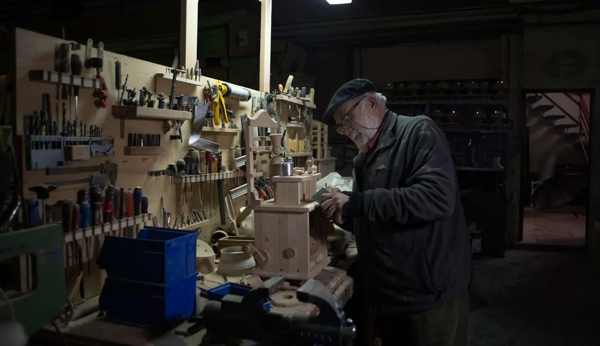 Francisco Jose Munoz (65) saat memproduksi mainan kayu di bengkelnya "Arbole" di Albolote dekat Granada, Spanyol (11/12). (AFP Photo/Jorge Guerrero)