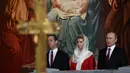 Presiden Rusia Vladimir Putin (kanan) bersama Perdana Menteri Rusia Dmitry Medvedev (kiri) dan istrinya Svetlana saat menjalani prosesi Paskah Ortodoks di Gereja Katedral Kristus Juru Selamat di Moskow, Rusia,(16/4). (AFP Photo / Vasily Maximov)