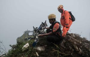 Personel tim pencarian dan penyelamatan melihat puing-puing pesawat turboprop Indonesia Air Transport berjenis ATR 42-500 di Gunung Bulusaraung, Sulawesi Selatan pada Minggu 18 Januari 2026. Tim gabungan terus mengoptimalkan operasi pencarian dan penyelamatan korban kecelakaan pesawat turboprop Indonesia Air Transport berjenis ATR 42-500 di Gunung Bulusaraung, Sulawesi Selatan. (Muchtamir Zaide/AFP)