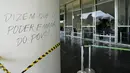 Ungkapan Portugis "Mereka mengatakan bahwa kekuasaan berasal dari rakyat" menutupi permukaan di luar Senat sehari setelah Gedung Kongres diserbu oleh pendukung mantan Presiden Brasil Jair Bolsonaro di Brasilia, Senin (9/1/2023). Para pengunjuk rasa juga menyerbu kantor kepresidenan, Istana Planalto, dan Mahkamah Agung. (AP Photo/Eraldo Peres)