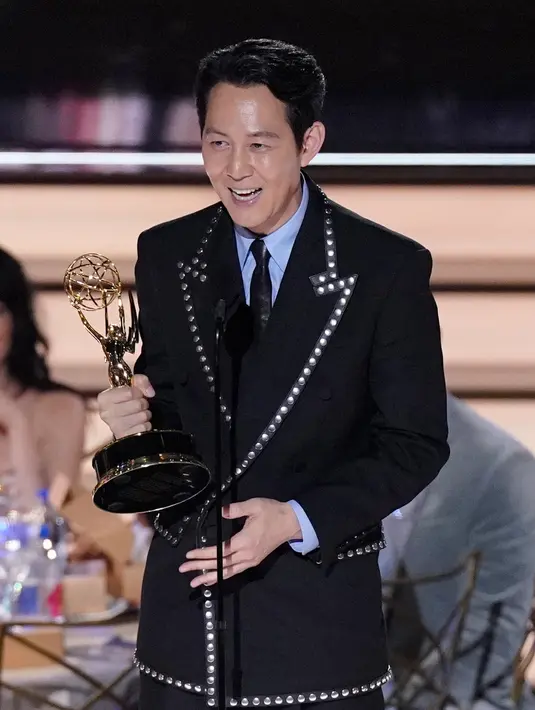 <p>Lee Jung-jae menerima penghargaan untuk kategori aktor utama terbaik dalam serial drama 'Squid Game' di Emmy Awards 2022 di Microsoft Theater, Los Angeles, Amerika Serikat, 12 September 2022. Selain Lee Jung-jae, sutradara Hwang Dong-hyuk juga menjadi orang Korea pertama yang mendapatkan penghargaan Emmy untuk penyutradaraan. (AP Photo/Mark Terrill)</p>