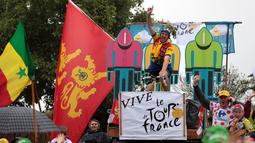 Seorang penonton bergaya ala pebalap saat menyambut kehadiran para peserta di Etape 2 Tour de France antara Saint-Lo dan Cherbourg-en-Cotentin, (3/7/2016). (AFP/Kenzo Tribouillard)