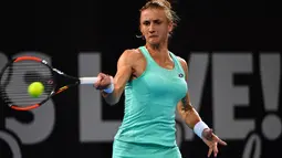Petenis dari Ukraina, Lesia Tsurenko memukul bola saat melawan petenis Australia Ashleigh Barty pada pertandingan putaran pertama turnamen tenis Brisbane International di Brisbane (1/1). (AFP Photo/Saeed Khan)