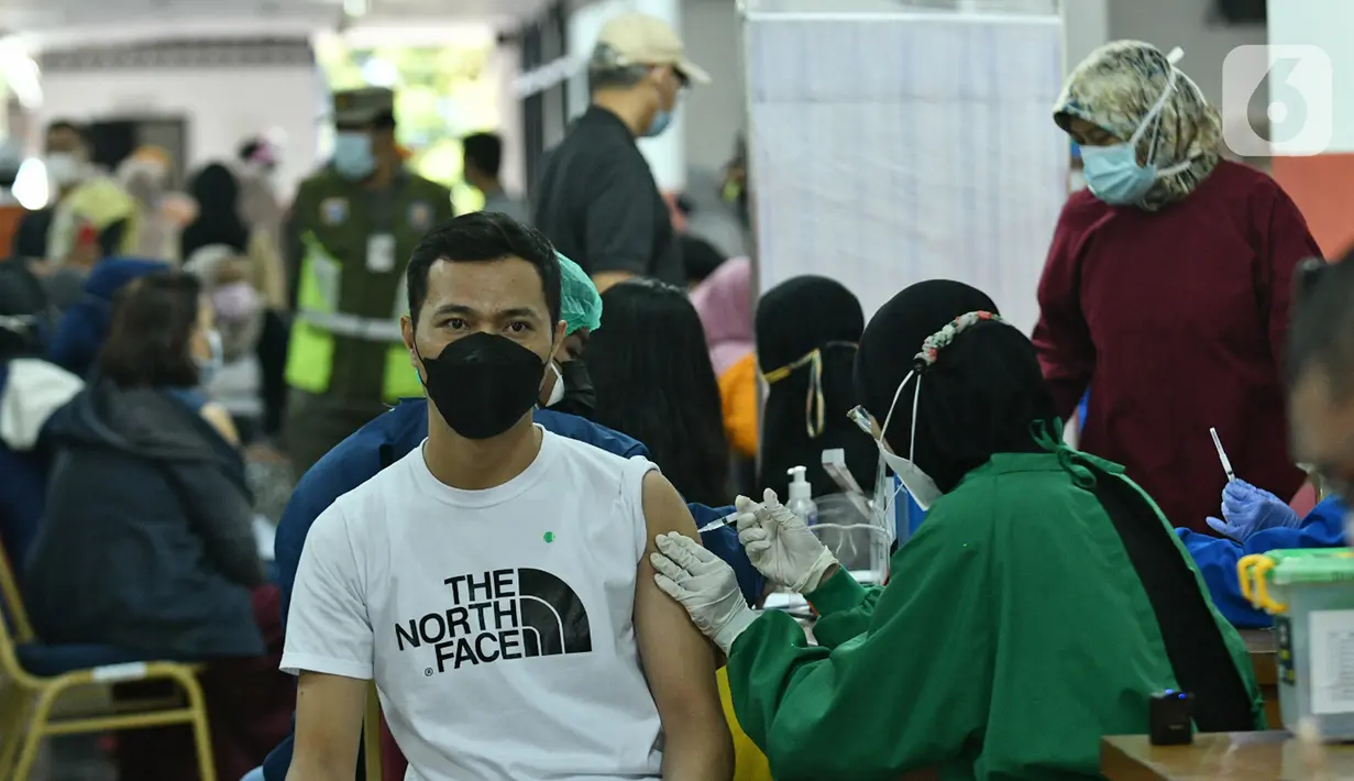 Warga mendapatkan vaksin Covid-19 di Gelanggang Olahraga (GOR) Ciracas, Jakarta Timur, Kamis (24/6/2021). GOR Ciracas resmi ditunjuk menjadi sentra vaksinasi Covid-19 untuk kelompok usia 18-50 tahun di wilayah Jakarta Timur. (Liputan6.com/Herman Zakharia)