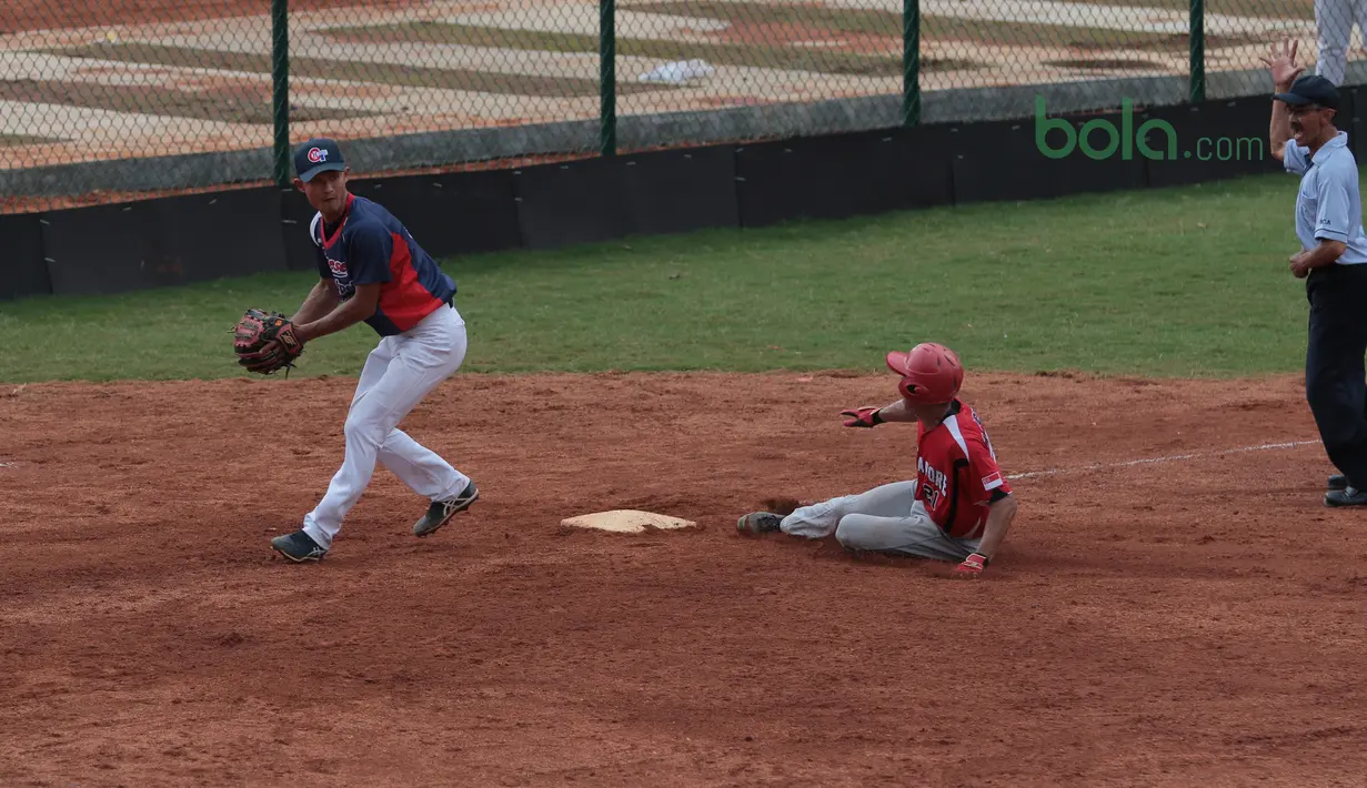 Pemain Singapura (tengah) menggapai base saat melawan Taiwan pada laga Asian Softball Championship di Senayan, Jakarta,Selasa (24/4/2018). Singapura menang 12-4. (Bola.com/Nick Hanoatubun)