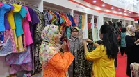 Pengunjung memilih pakaian di Naung Songket yang merupakan binaan Yayasan Dharma Bhakti Astra (YDBA) pada pameran kerajinan INACRAFT 2019 di Jakarta. Sebanyak 8 UKM binaan YDBA telah mengikuti technical meeting serta pelatihan marketing sebagai bekal dalam mengikuti pameran. (Liputan6.com/HO/Eko)