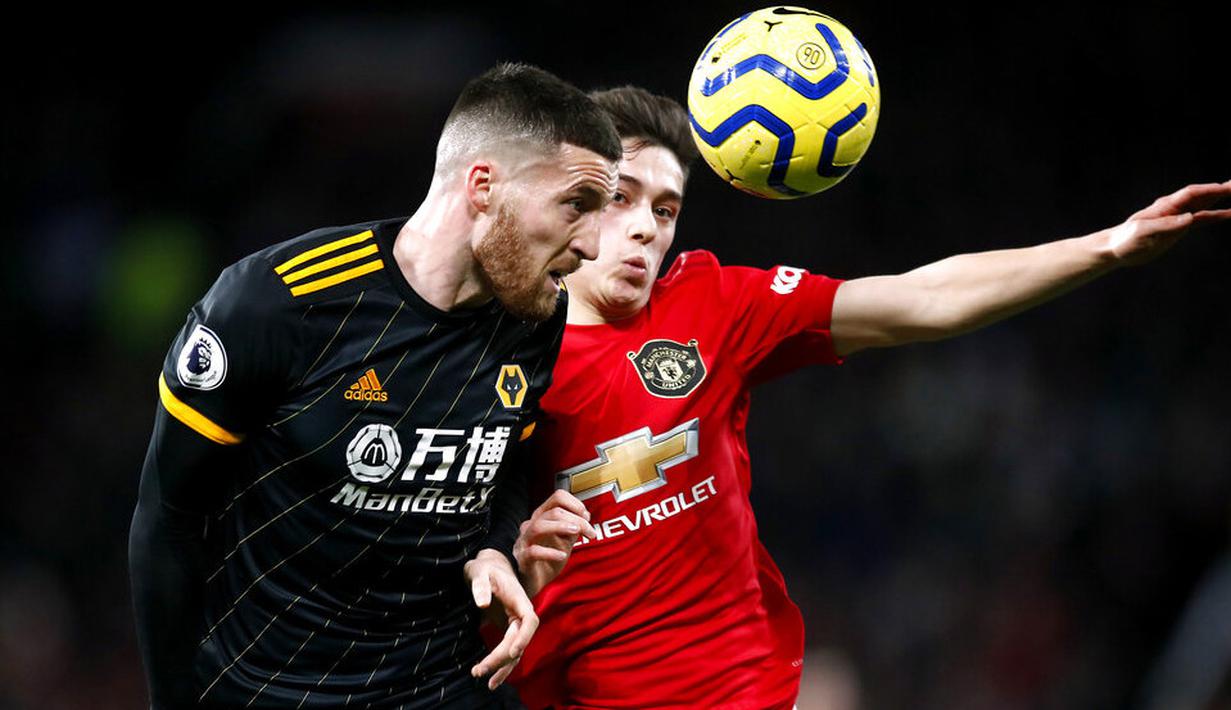Gelandang Manchester United, Daniel James, duel udara dengan pemain Wolverhampton Wanderers, Matt Doherty, pada laga Premier League di Stadion Old Trafford, Sabtu (1/2/2020). Kedua tim bermain imbang tanpa gol. (AP/Martin Rickett)