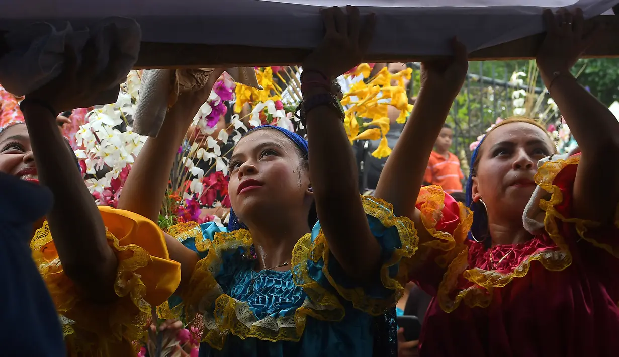 Sejumlah anak-anak mengenakan kostum berpartisipasi dalam acara festival tahunan Panchimalco Flower and Palm Festival di Panchimalco, San Salvador (6/5). Pada perayaan ini, warga setempat menghias daun kelapa dengan bunga. (AFP/Marvin Recinos)