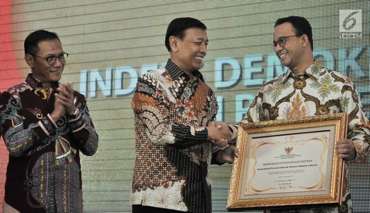 Gubernur DKI Jakarta Anies Baswedan (kanan) menerima piagam penghargaan Indeks Demokrasi Indonesia (IDI) 2017 dari Menko Polhukam Wiranto di Jakarta, Kamis (13/12). DKI Jakarta meraih peringkat pertama kategori IDI terbaik. (Merdeka.com/Iqbal Nugroho)