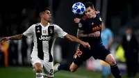 Bek Juventus, Joao Cancelo, berebut bola dengan striker Valencia, Santi Mina, pada laga Liga Champions di Stadion Allianz, Turin, Selasa (27/11). Juventus menang 1-0 atas Valencia. (AFP/Marco Bertorello)