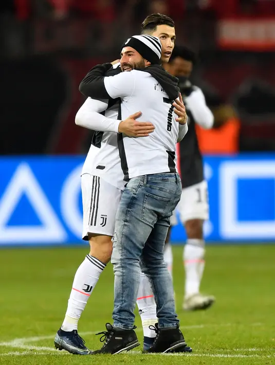 Seorang penyusup yang masuk ke lapangan memeluk Cristiano Ronaldo saat laga Juventus melawan Bayer Leverkusen pada pertandingan Liga Champions di Bay Arena, Leverkusen, Jerman, Rabu (11/12/2019). (AP Photo/Martin Meissner)