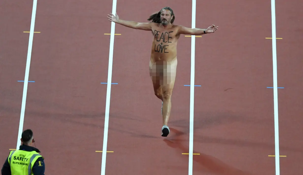Pria tanpa busana memasuki track atletik dalam Kejuaraan Atletik Dunia London 2017 di Stadion London, London, (5/8). Pria ini berhasil diamankan sebelum final sprint 100 m putra berlangsung. (AFP Photo/Antonin Thuillier)