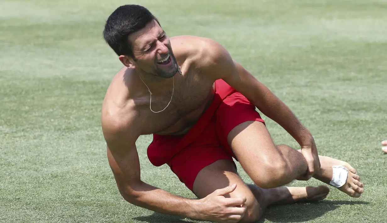 Petenis asal Serbia, Novak Djokovic terlihat kesakitan saat bermain sepakbola bersama timnya jelang bertanding melawan Cristian Garin dari Chile pada hari keenam turnamen tenis ATP Cup di Brisbane, Australia, Rabu (8/1/2020). (AP Photo/Tertius Pickard)