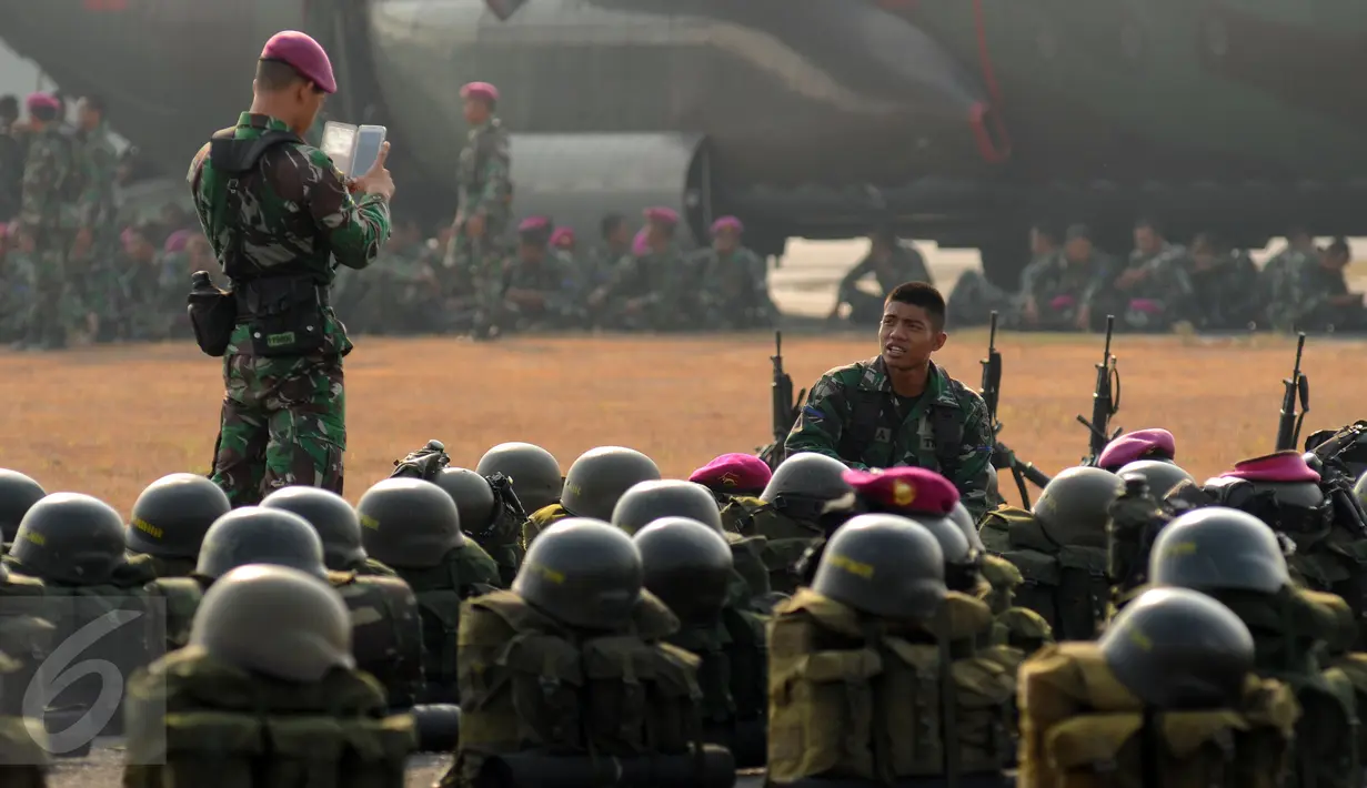 Prajurit TNI yang tergabung dalam Satgas Pemadaman Kebakaran Hutan dan Lahan berfoto jelang keberangkatan ke Sumatera Selatan di Lanud Halim Perdanakusuma Jakarta, Kamis (22/10). Satgas ini akan bertugas selama 2 bulan. (Liputan6.com/Helmi Fithriansyah)